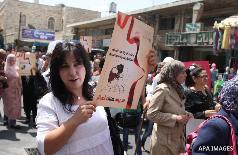 Palestinian women hold signs during a demonstration protesting violence against women held at the spot where a woman's throat was allegedly slashed by her husband on Monday, in the West Bank town of Bethlehem, Wednesday,...