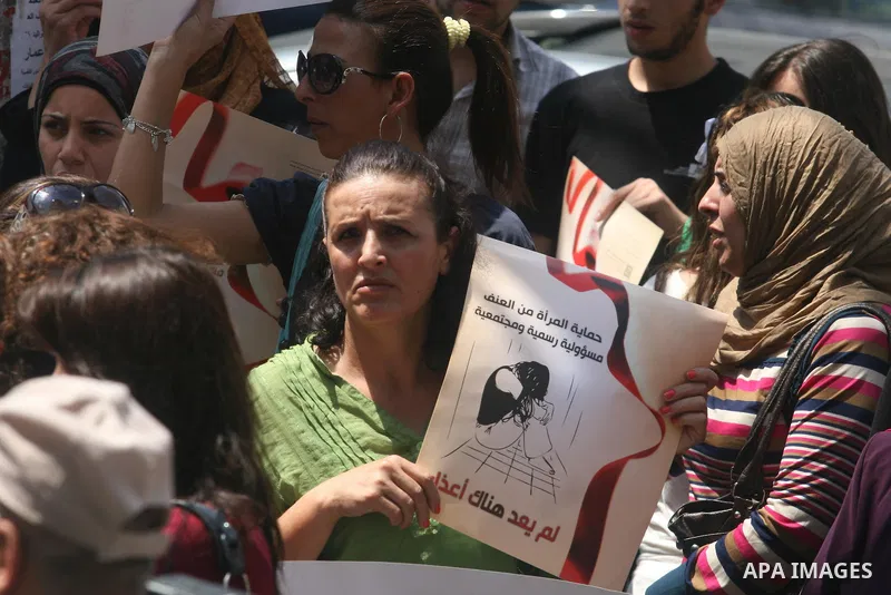 Palestinian women hold signs during a demonstration protesting violence against women held at the spot where a woman's throat was allegedly slashed by her husband on Monday, in the West Bank town of Bethlehem, Wednesday,...