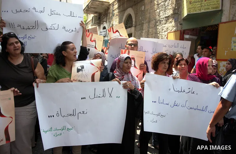 Palestinian women hold signs during a demonstration protesting violence against women held at the spot where a woman's throat was allegedly slashed by her husband on Monday, in the West Bank town of Bethlehem, Wednesday,...