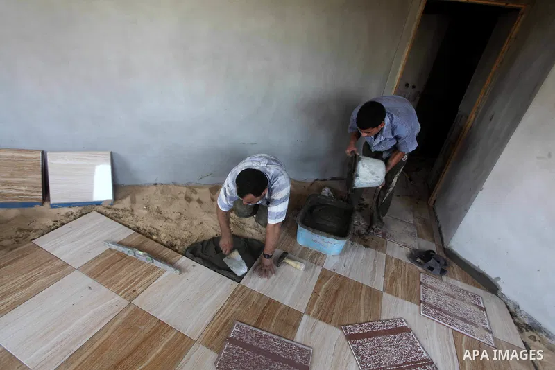 Palestinian laborers work in flooring during the holy month of Ramadan, in Deir al-Balah in central Gaza Strip on 02 August 2012. During Ramadan, eating, drinking, sex and smoking is banned and restaurants are forbidden...