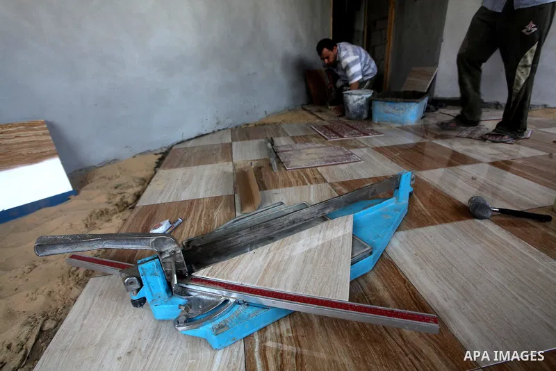 Palestinian laborers work in flooring during the holy month of Ramadan, in Deir al-Balah in central Gaza Strip on 02 August 2012. During Ramadan, eating, drinking, sex and smoking is banned and restaurants are forbidden...