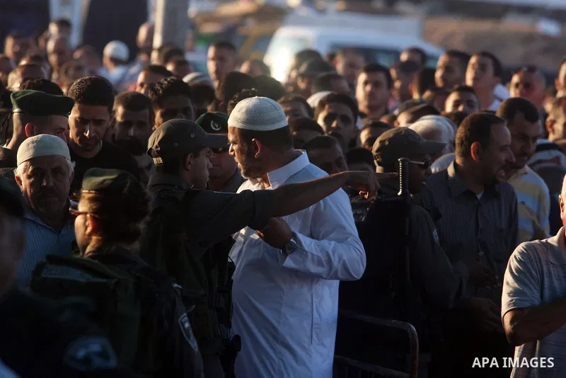Palestinians wait to cross to Jerusalem from the Qalandia checkpoint near the West Bank city of Ramallah on Aug. 3, 2012. Palestinian Muslims are heading to Jerusalem to attend the third Friday prayers of the fasting mon...
