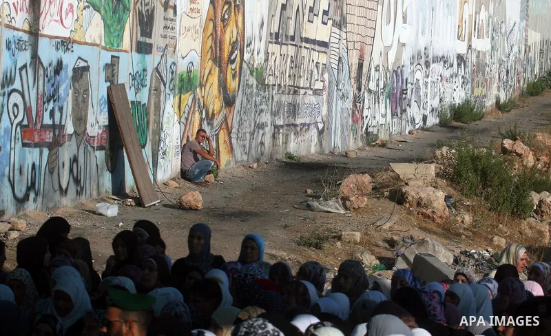 Palestinians wait to cross to Jerusalem from the Qalandia checkpoint near the West Bank city of Ramallah on Aug. 3, 2012. Palestinian Muslims are heading to Jerusalem to attend the third Friday prayers of the fasting mon...