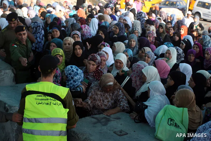 Palestinians wait to cross to Jerusalem from the Qalandia checkpoint near the West Bank city of Ramallah on Aug. 3, 2012. Palestinian Muslims are heading to Jerusalem to attend the third Friday prayers of the fasting mon...