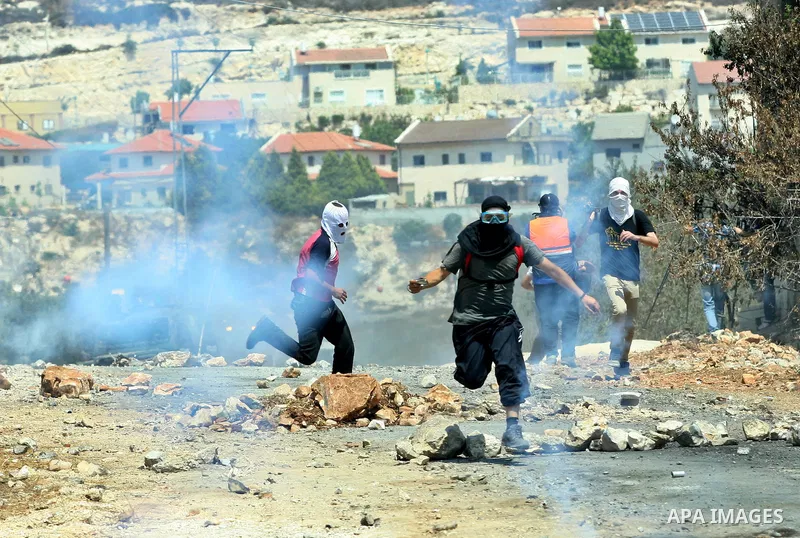 Palestinian protestors run for cover from tear gas fired by Israeli soldiers during a demonstration against the expropriation of Palestinian land by Israel in the village of Kafr Qaddum, near the West Bank city of Nablus...