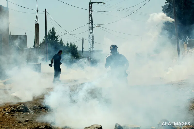 Palestinian protestors run for cover from tear gas fired by Israeli soldiers during a demonstration against the expropriation of Palestinian land by Israel in the village of Kafr Qaddum, near the West Bank city of Nablus...