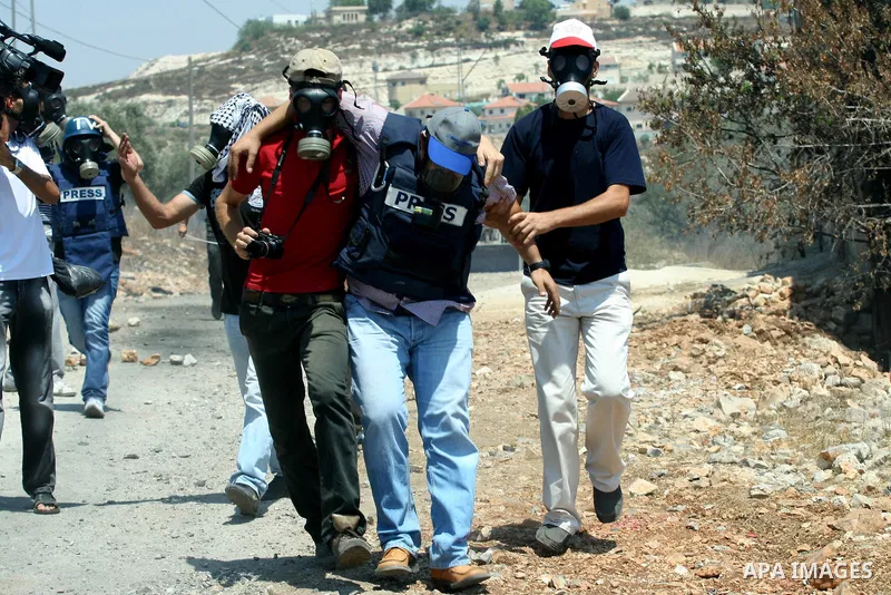 Palestinian protestors help a journalist injured by Israeli soldiers during a demonstration against the expropriation of Palestinian land by Israel in the village of Kafr Qaddum, near the West Bank city of Nablus on Aug....