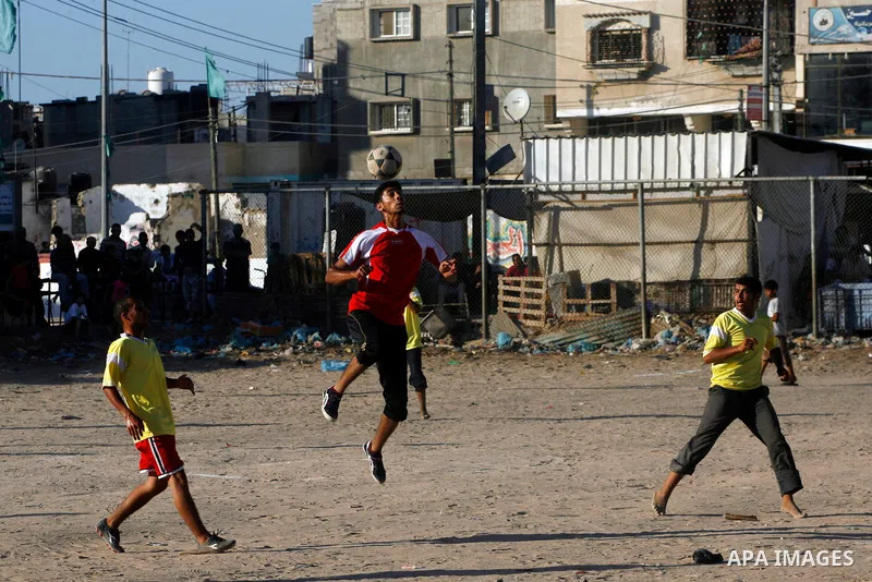 Palestinian youths play football before breaking fast in southern Gaza strip town of Rafah, on 03 August 2012. Muslims fasting in the month of Ramadan must abstain from food, drink and sex from dawn until sunset. Photo b...