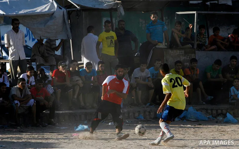 Palestinian youths play football before breaking fast in southern Gaza strip town of Rafah, on 03 August 2012. Muslims fasting in the month of Ramadan must abstain from food, drink and sex from dawn until sunset. Photo b...
