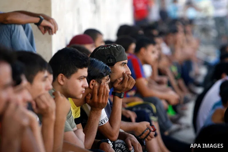 Palestinian youths watch a football match before breaking fast in southern Gaza strip town of Rafah, on 03 August 2012. Muslims fasting in the month of Ramadan must abstain from food, drink and sex from dawn until sunset...