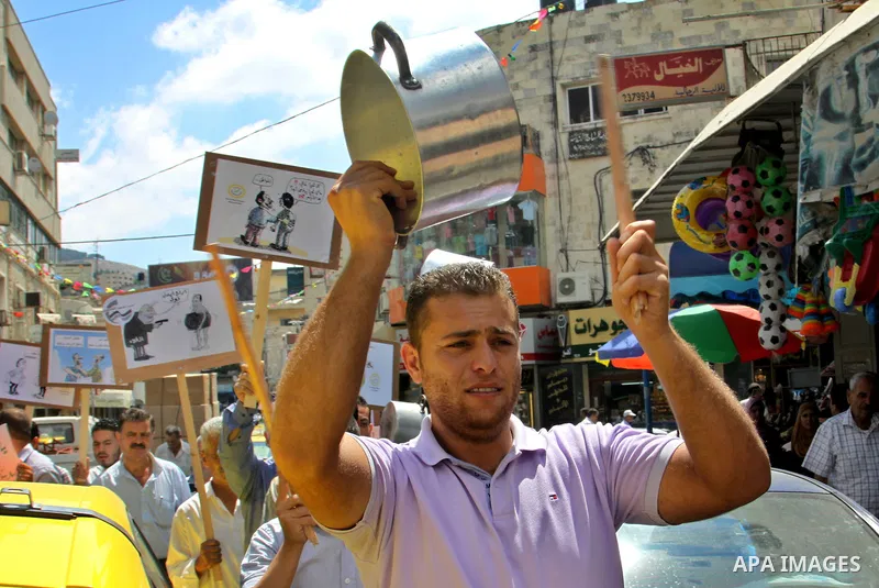 Palestinian demonstrators bang on pots during protest against rising prices and taxes in the West Bank, city of Nablus Aug. 04, 2012. Photo by Nedal Eshtayah