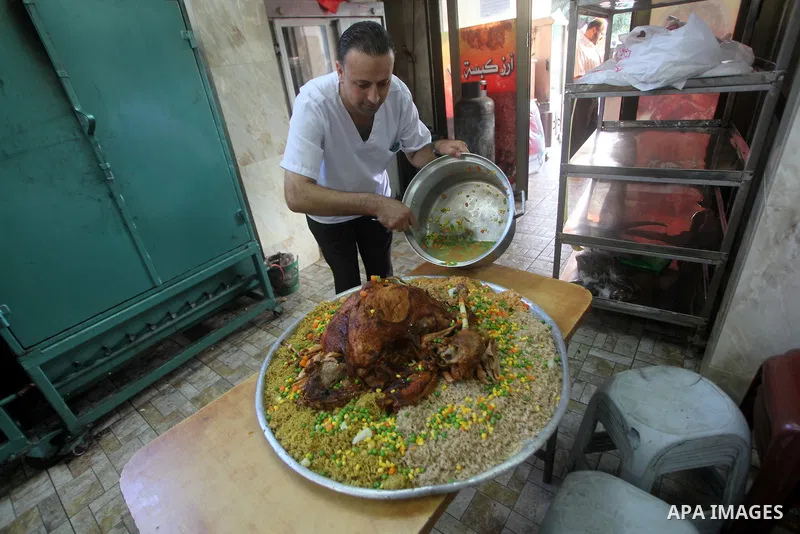 Palestinians prepare rice and meats as they wait for customers several hours before Iftar, the breaking of the day long Ramadan fast in Gaza City, on Aug. 04, 2012. Muslims around the world refrain from eating, drinking...