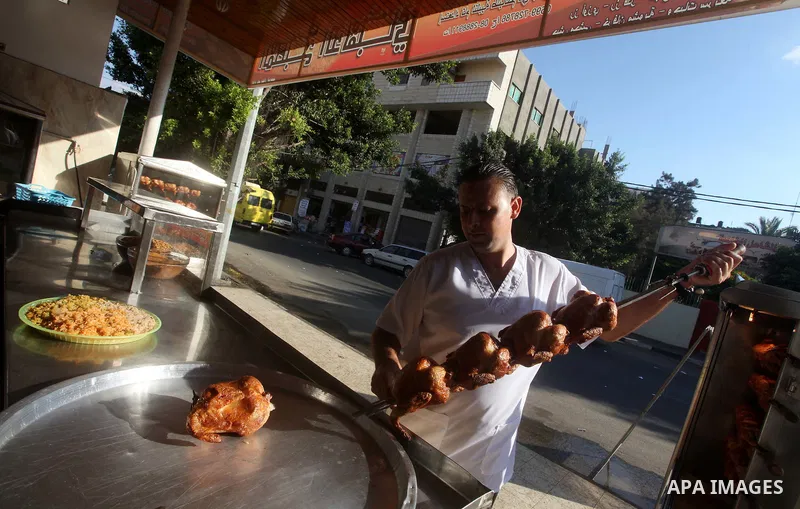 Palestinians prepare chicken as they wait for customers several hours before Iftar, the breaking of the day long Ramadan fast in Gaza City, on Aug. 04, 2012. Muslims around the world refrain from eating, drinking and sex...