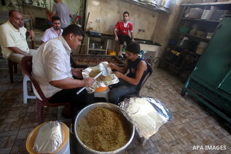 Palestinians prepare rice as they wait for customers several hours before Iftar, the breaking of the day long Ramadan fast in Gaza City, on Aug. 04, 2012. Muslims around the world refrain from eating, drinking and sexual...