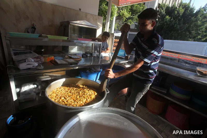 Palestinians prepare rice as they wait for customers several hours before Iftar, the breaking of the day long Ramadan fast in Gaza City, on Aug. 04, 2012. Muslims around the world refrain from eating, drinking and sexual...