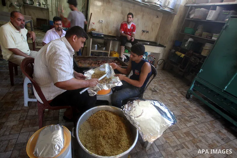Palestinians prepare rice as they wait for customers several hours before Iftar, the breaking of the day long Ramadan fast in Gaza City, on Aug. 04, 2012. Muslims around the world refrain from eating, drinking and sexual...