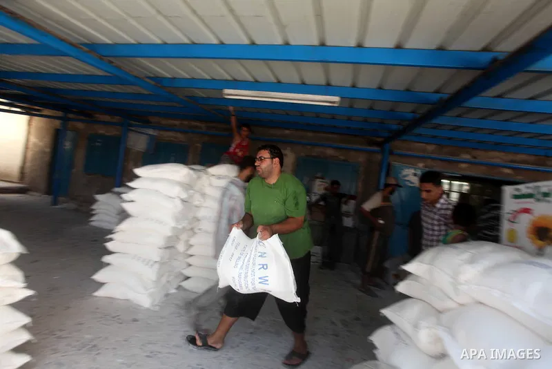 A Palestinian man carries a sack of flour at a UN Relief and Works Agency (UNRWA) warehouse in the Shati refugee camp, in Gaza City, on Aug. 05, 2012. UNRWA launched Sunday its Gaza Ramadan Appeal for 5000 food parcels i...