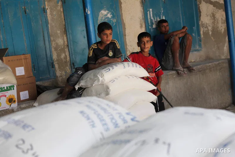 Palestinians receive their food aid at a UN Relief and Works Agency (UNRWA) warehouse in the Shati refugee camp, in Gaza City, on Aug. 05, 2012. UNRWA launched Sunday its Gaza Ramadan Appeal for 5000 food parcels in orde...