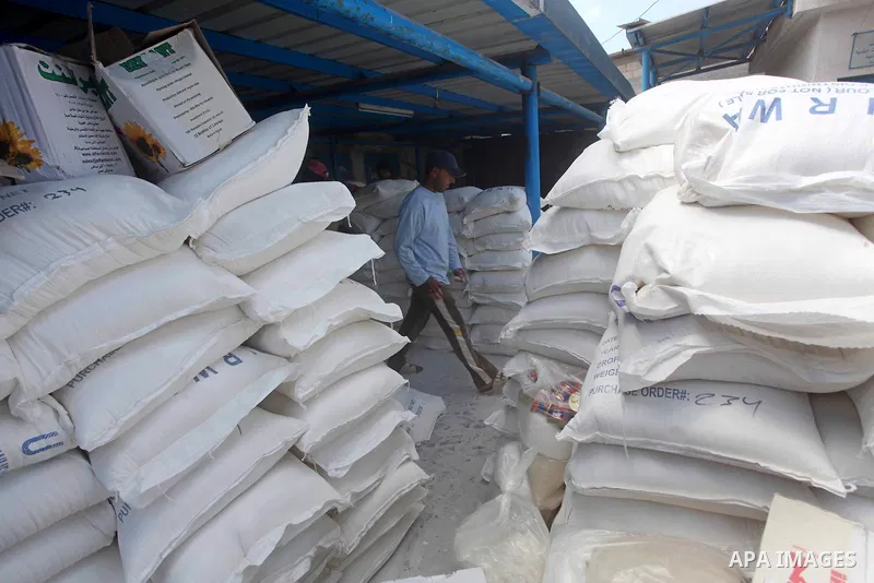 A Palestinian youth carries a sack of flour at a UN Relief and Works Agency (UNRWA) warehouse in the Shati refugee camp, in Gaza City, on Aug. 05, 2012. UNRWA launched Sunday its Gaza Ramadan Appeal for 5000 food parcels...