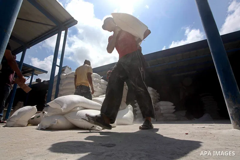 A Palestinian youth carries a sack of flour at a UN Relief and Works Agency (UNRWA) warehouse in the Shati refugee camp, in Gaza City, on Aug. 05, 2012. UNRWA launched Sunday its Gaza Ramadan Appeal for 5000 food parcels...
