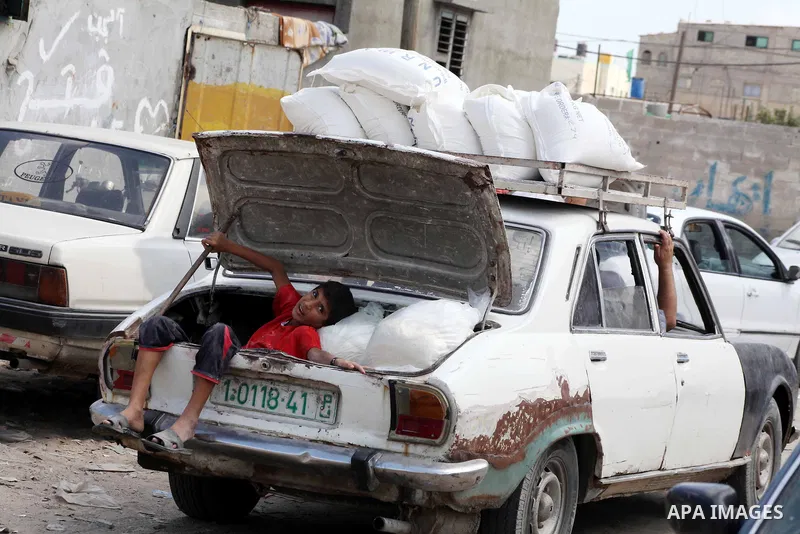 Palestinians receive their food aid at a UN Relief and Works Agency (UNRWA) warehouse in the Shati refugee camp, in Gaza City, on Aug. 05, 2012. UNRWA launched Sunday its Gaza Ramadan Appeal for 5000 food parcels in orde...