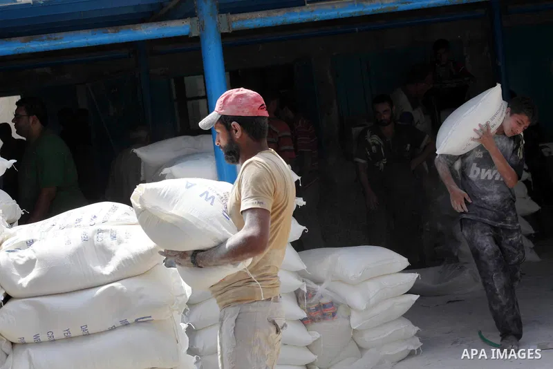 A Palestinian man carries a sack of flour at a UN Relief and Works Agency (UNRWA) warehouse in the Shati refugee camp, in Gaza City, on Aug. 05, 2012. UNRWA launched Sunday its Gaza Ramadan Appeal for 5000 food parcels i...