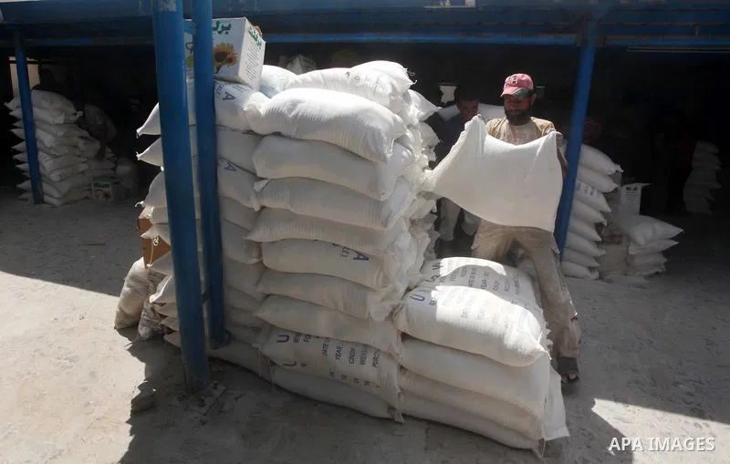 A Palestinian man carries a sack of flour at a UN Relief and Works Agency (UNRWA) warehouse in the Shati refugee camp, in Gaza City, on Aug. 05, 2012. UNRWA launched Sunday its Gaza Ramadan Appeal for 5000 food parcels i...