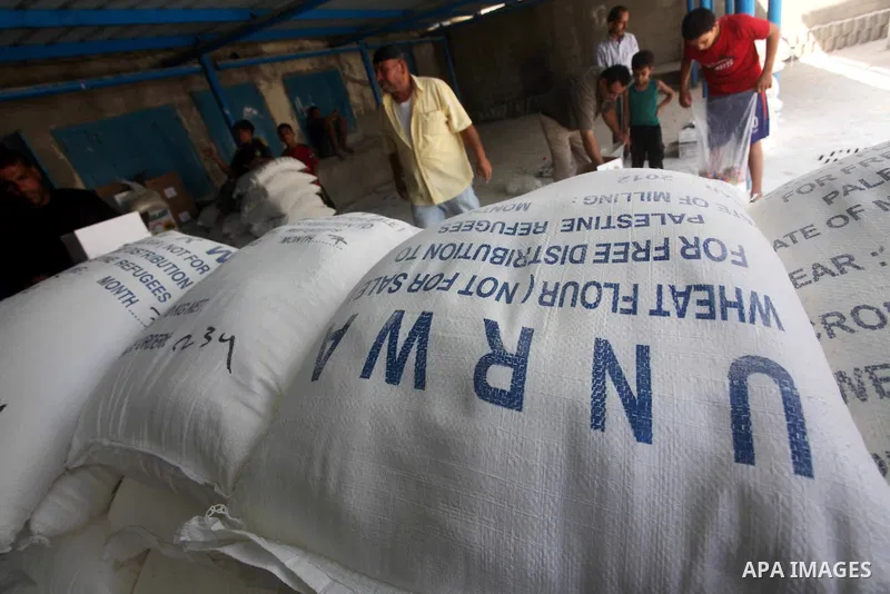 Palestinians receive their food aid at a UN Relief and Works Agency (UNRWA) warehouse in the Shati refugee camp, in Gaza City, on Aug. 05, 2012. UNRWA launched Sunday its Gaza Ramadan Appeal for 5000 food parcels in orde...