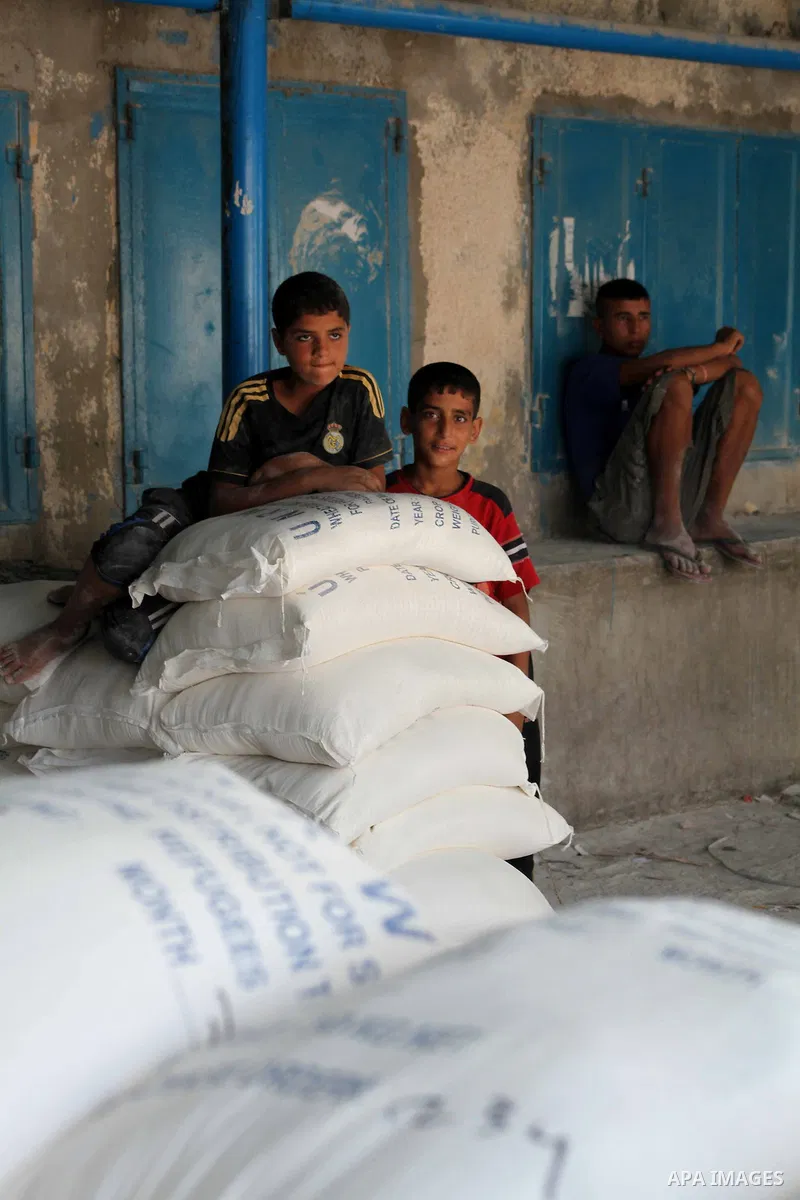 Palestinians receive their food aid at a UN Relief and Works Agency (UNRWA) warehouse in the Shati refugee camp, in Gaza City, on Aug. 05, 2012. UNRWA launched Sunday its Gaza Ramadan Appeal for 5000 food parcels in orde...