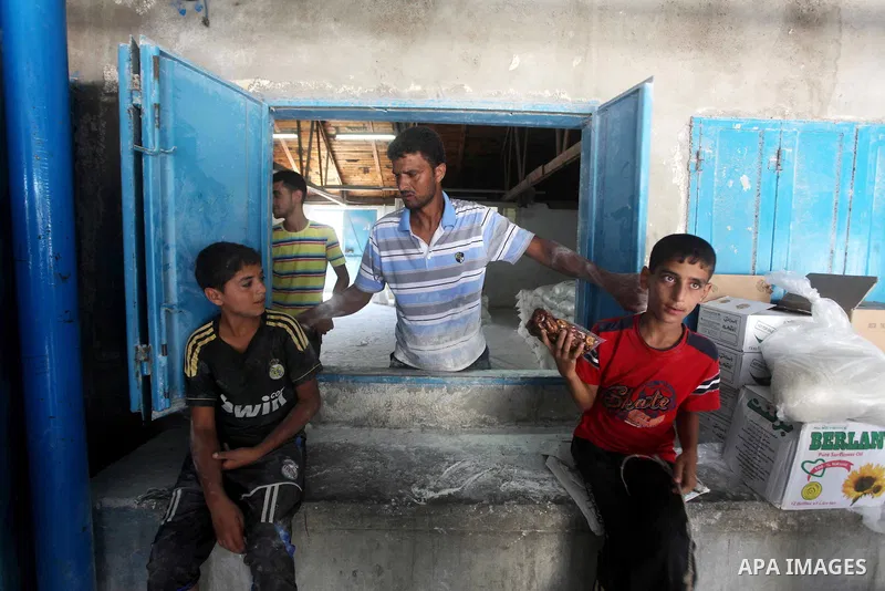 Palestinians receive their food aid at a UN Relief and Works Agency (UNRWA) warehouse in the Shati refugee camp, in Gaza City, on Aug. 05, 2012. UNRWA launched Sunday its Gaza Ramadan Appeal for 5000 food parcels in orde...