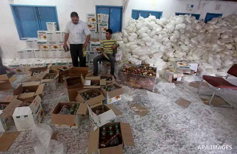 Palestinians receive their food aid at a UN Relief and Works Agency (UNRWA) warehouse in the Shati refugee camp, in Gaza City, on Aug. 05, 2012. UNRWA launched Sunday its Gaza Ramadan Appeal for 5000 food parcels in orde...