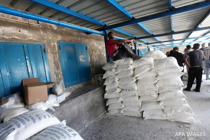 Palestinians receive their food aid at a UN Relief and Works Agency (UNRWA) warehouse in the Shati refugee camp, in Gaza City, on Aug. 05, 2012. UNRWA launched Sunday its Gaza Ramadan Appeal for 5000 food parcels in orde...