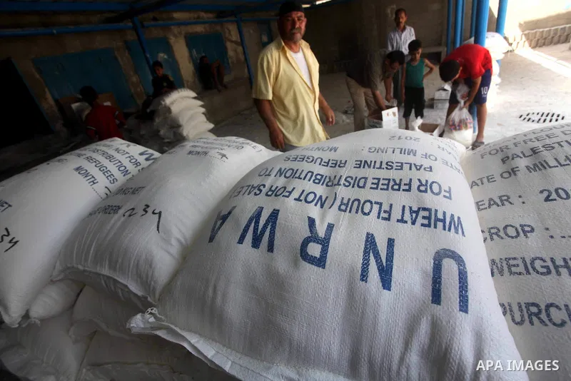 Palestinians receive their food aid at a UN Relief and Works Agency (UNRWA) warehouse in the Shati refugee camp, in Gaza City, on Aug. 05, 2012. UNRWA launched Sunday its Gaza Ramadan Appeal for 5000 food parcels in orde...