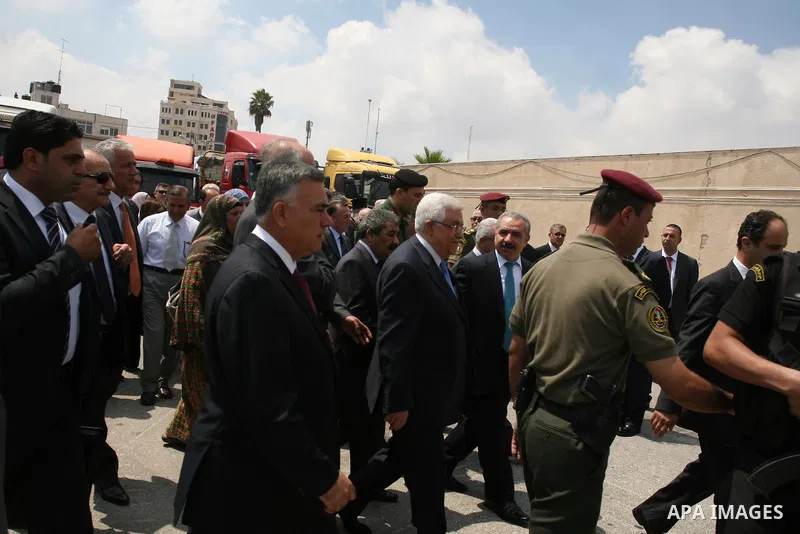 Palestinian President Mahmoud Abbas, accompanied by other officials as he inspects a convoy of trucks carrying food and medical supplies, which reportedly were provided by the Palestinian people, leaving Ramallah bound f...