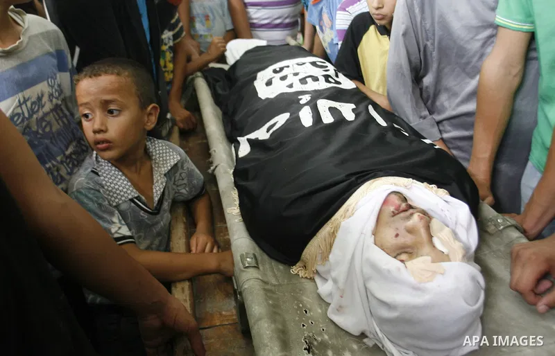 Mourners over the body of a Palestinian militant Eid Hejazi during his funeral in Rafah, southern Gaza Strip, Sunday, Aug. 5, 2012. Hejazi was killed on an Israeli air strike on Sunday and was a member of the Popular Res...