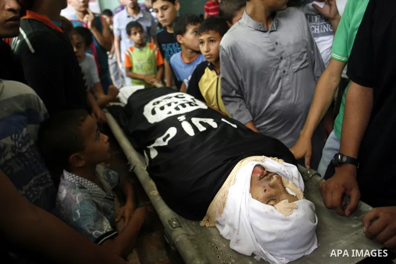 Mourners over the body of a Palestinian militant Eid Hejazi during his funeral in Rafah, southern Gaza Strip, Sunday, Aug. 5, 2012. Hejazi was killed on an Israeli air strike on Sunday and was a member of the Popular Res...