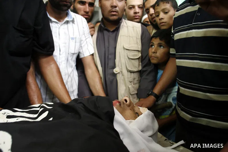Mourners over the body of a Palestinian militant Eid Hejazi during his funeral in Rafah, southern Gaza Strip, Sunday, Aug. 5, 2012. Hejazi was killed on an Israeli air strike on Sunday and was a member of the Popular Res...