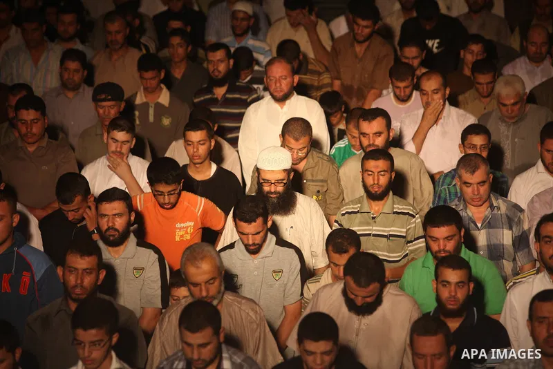 Palestinian Prime Minister in Gaza Ismail Haniyeh (not seen) leads a night prayer known as "Tarawih" at a sit-in tent in Gaza city, solidarity with Egyptian soldiers who were killed on Rafah border between Egypt and the...