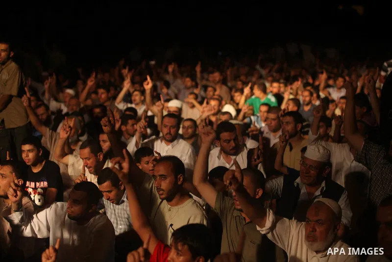 Palestinians chant slogans following a night prayer known as "Tarawih" leads by Palestinian Prime Minister in Gaza Ismail Haniyeh at a sit-in tent in Gaza city, solidarity with Egyptian soldiers who were killed on Rafah...