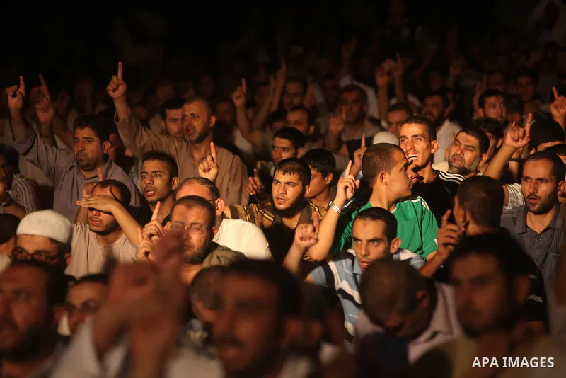 Palestinians chant slogans following a night prayer known as "Tarawih" leads by Palestinian Prime Minister in Gaza Ismail Haniyeh at a sit-in tent in Gaza city, solidarity with Egyptian soldiers who were killed on Rafah...