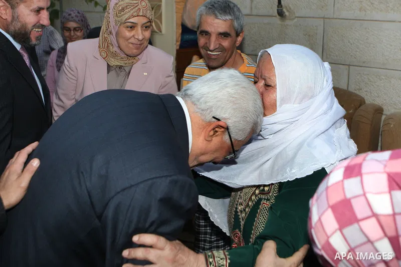 A Palestinian woman kisses Palestinian President Mahmoud Abbas (Abu Mazen) during a visit to a Palestinian indigent family , in the West Bank city of Ramallah on 06 August 2012. Photo by Thaer Ganaim