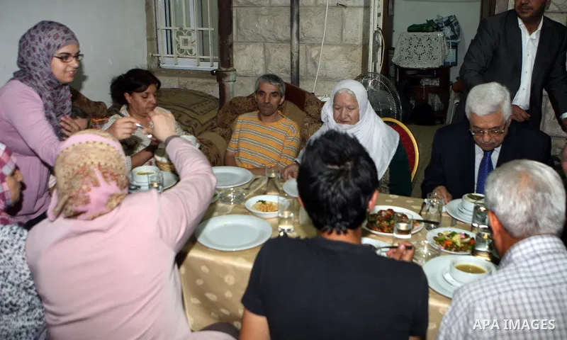 Palestinian President Mahmoud Abbas (Abu Mazen) breaks his fast with a Palestinian indigent family during the holy month of Ramadan, in the West Bank city of Ramallah on 06 August 2012. Photo by Thaer Ganaim