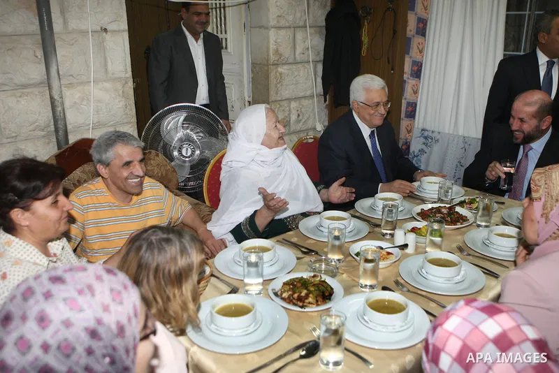 Palestinian President Mahmoud Abbas (Abu Mazen) breaks his fast with a Palestinian indigent family during the holy month of Ramadan, in the West Bank city of Ramallah on 06 August 2012. Photo by Thaer Ganaim