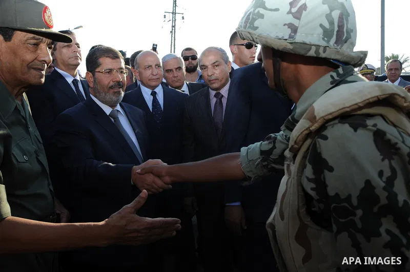 Egypt's President Mohamed Mursi gestures, while Field Marshal Hussein Tantawi, and an army general look on at a checkpoint in al-Arish August 6, 2012. Egypt branded Islamist gunmen who killed 16 police near the Israeli b...
