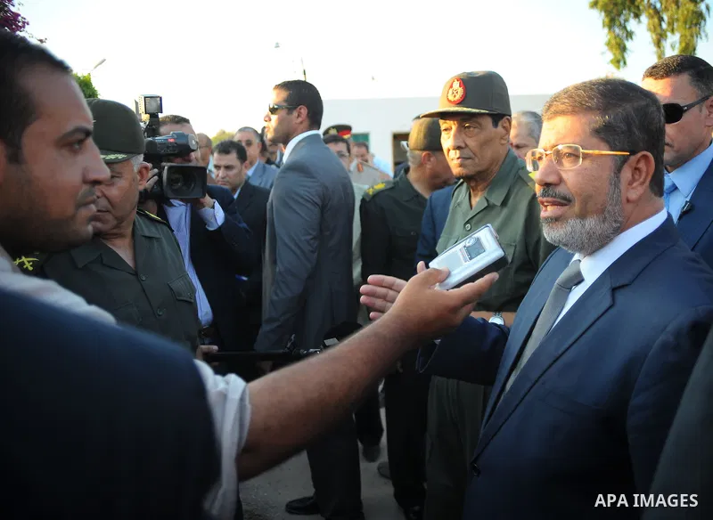 Egypt's President Mohamed Mursi gestures, while Field Marshal Hussein Tantawi, and an army general look on at a checkpoint in al-Arish August 6, 2012. Egypt branded Islamist gunmen who killed 16 police near the Israeli b...