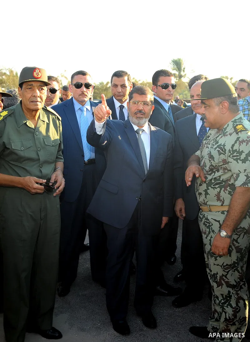 Egypt's President Mohamed Mursi gestures, while Field Marshal Hussein Tantawi, and an army general look on at a checkpoint in al-Arish August 6, 2012. Egypt branded Islamist gunmen who killed 16 police near the Israeli b...