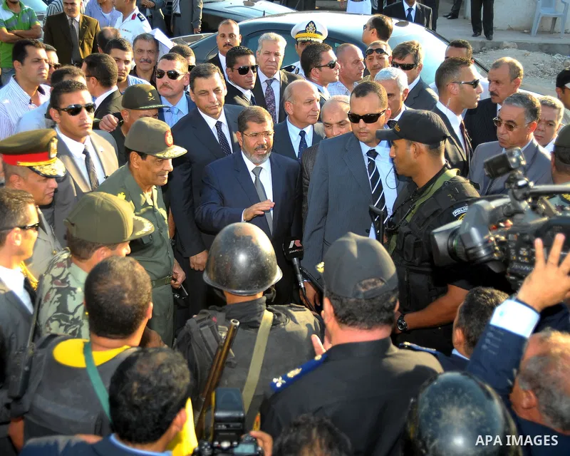 Egypt's President Mohamed Mursi gestures, while Field Marshal Hussein Tantawi, and an army general look on at a checkpoint in al-Arish August 6, 2012. Egypt branded Islamist gunmen who killed 16 police near the Israeli b...