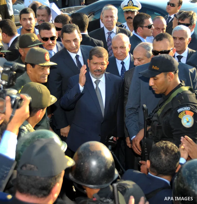 Egypt's President Mohamed Mursi gestures, while Field Marshal Hussein Tantawi, and an army general look on at a checkpoint in al-Arish August 6, 2012. Egypt branded Islamist gunmen who killed 16 police near the Israeli b...