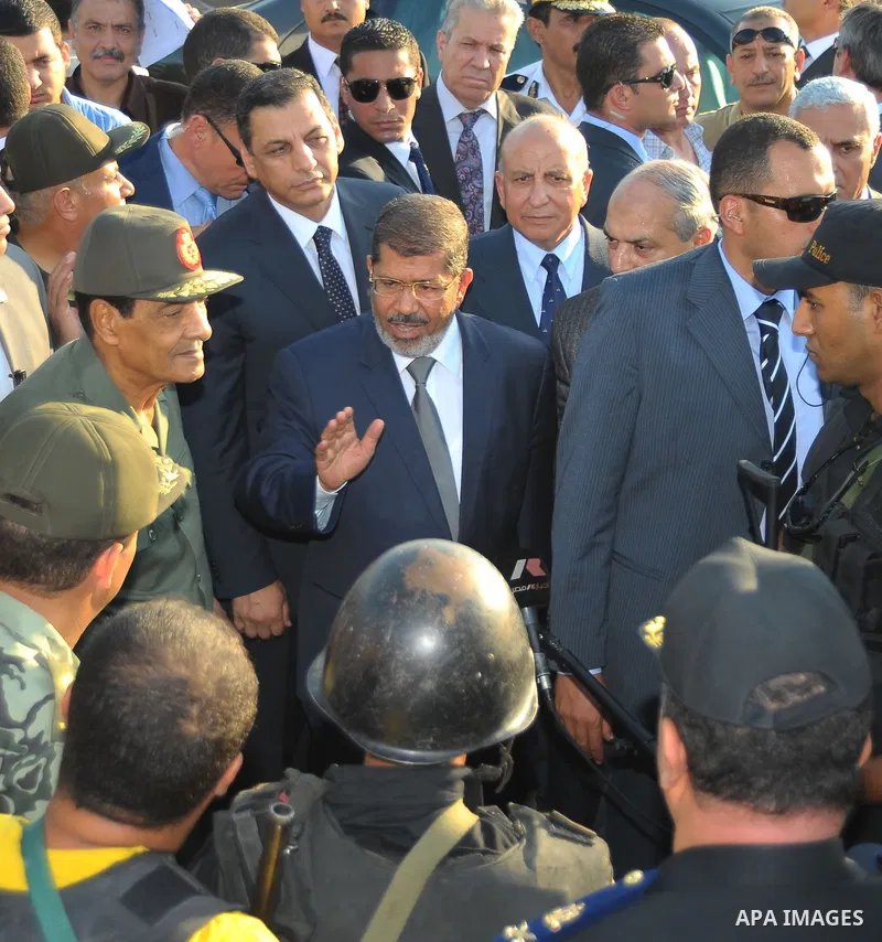 Egypt's President Mohamed Mursi gestures, while Field Marshal Hussein Tantawi, and an army general look on at a checkpoint in al-Arish August 6, 2012. Egypt branded Islamist gunmen who killed 16 police near the Israeli b...