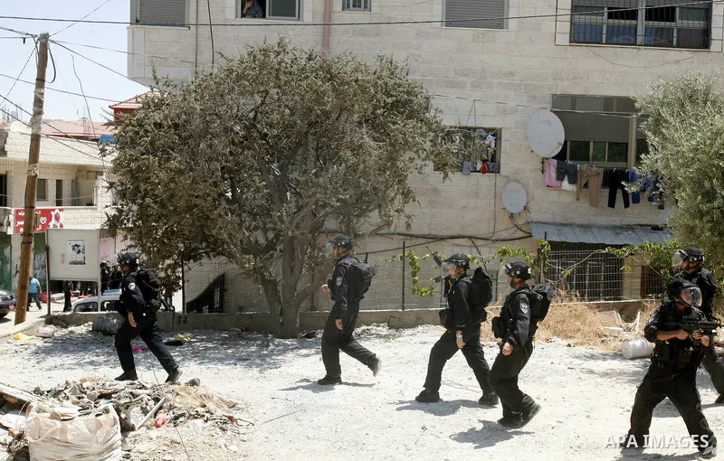 Israeli policemen run with their weapons during stormed in the West Bank town of Issawiya, in the West Bank, on Aug. 07, 2012. Photo by Mahfouz Abu Turk